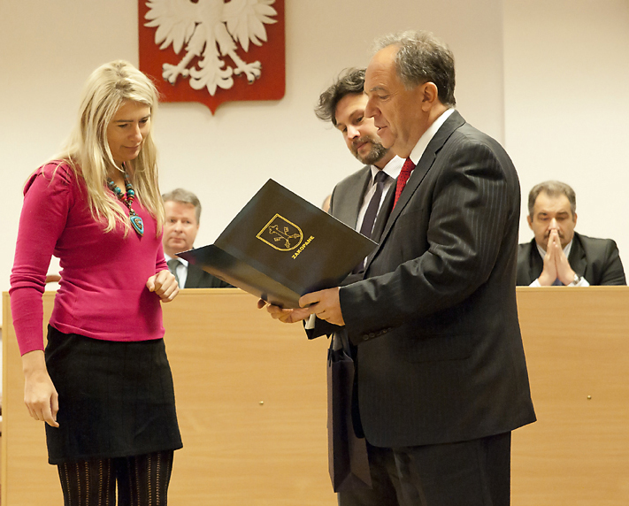 Renata otrzymuje od burmistrza Janusza Majchra uroczysty adres. Obok wiceburmistrz Mariusz Koperski.
